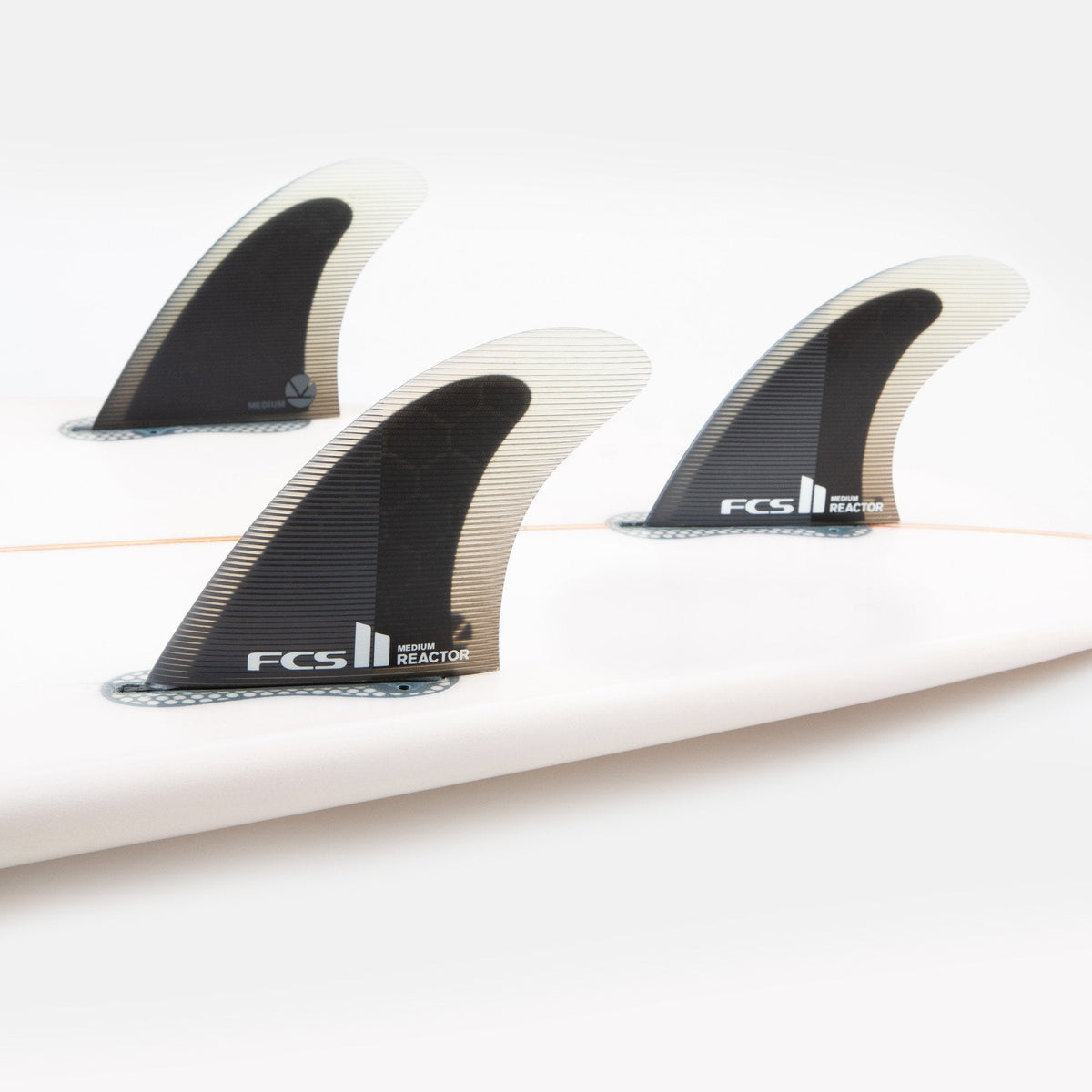 FCS II Reactor Tri Fins - Performance Core: three Reactor fins installed on a white board