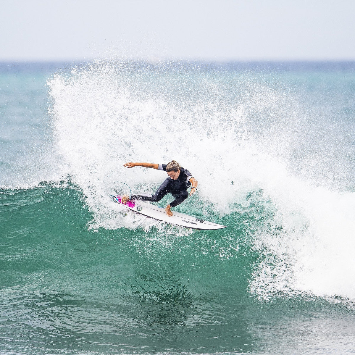 FCS II Sally Fitzgibbons Tri Fins - Performance Core: sally Fitzgibbons carving a breaking wave with spray
