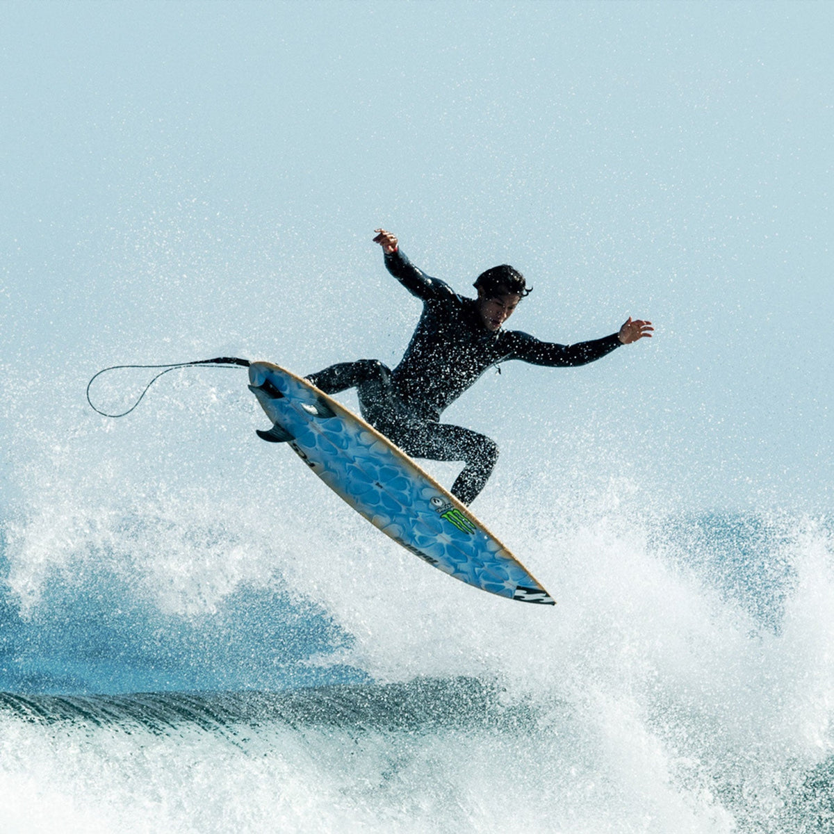 FCS II Tokoro Tri Fins - Performance Core: surfer performing an aerial above whitewater