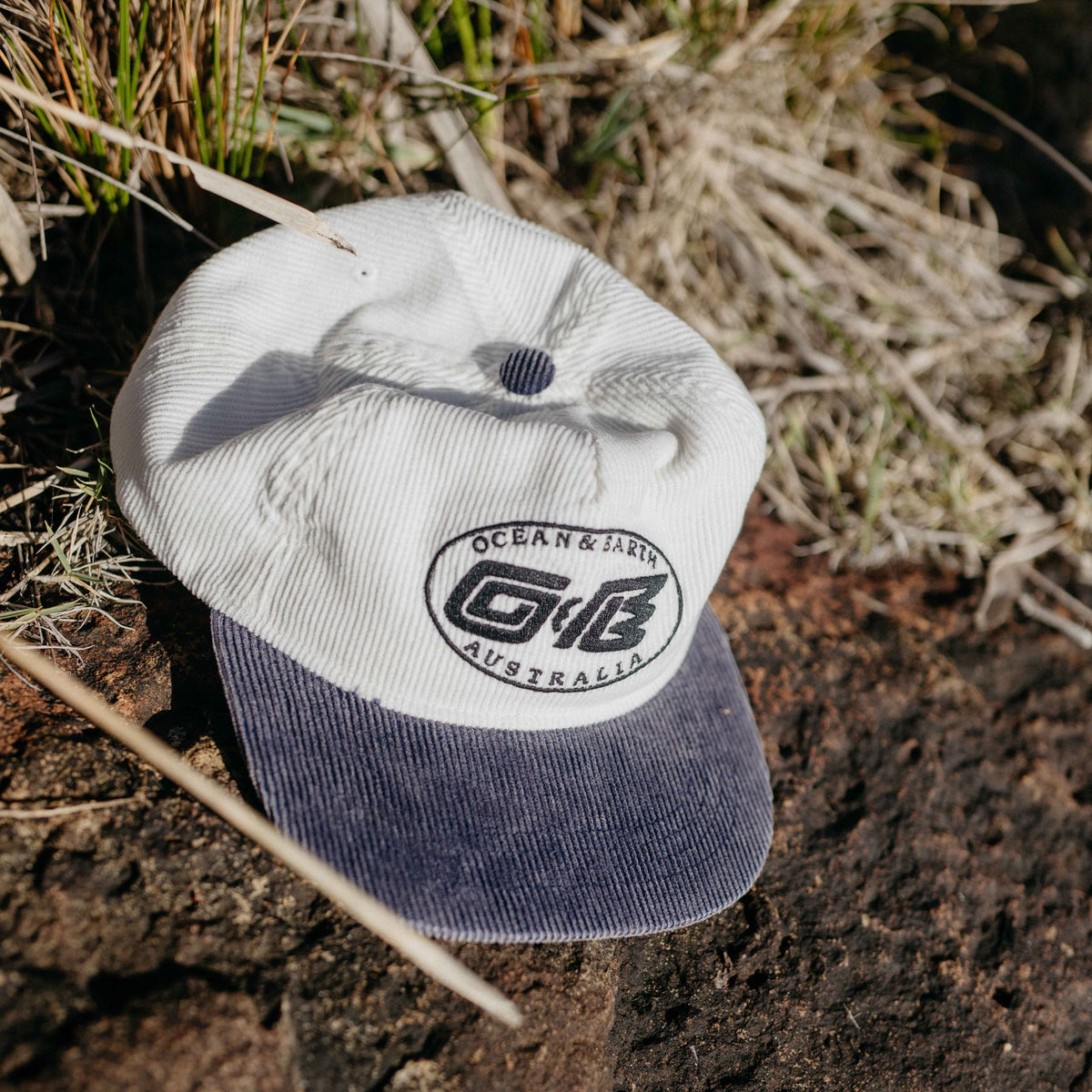 Ocean & Earth Heritage Cap: Antique White cap resting outdoors