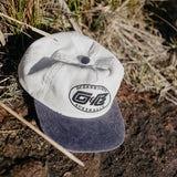 Ocean & Earth Heritage Cap: Antique White cap resting outdoors