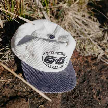 Ocean & Earth Heritage Cap: Antique White cap resting outdoors