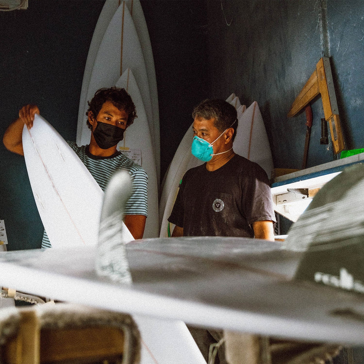 FCS II Tokoro Tri Fins - Performance Core: two people inspecting a board in a shaping room