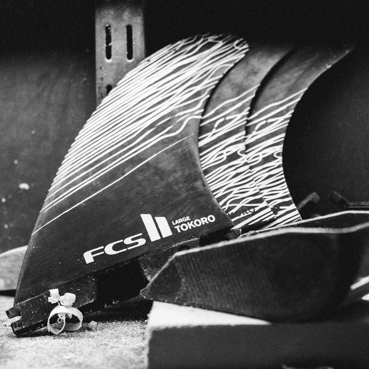 FCS II Tokoro Tri Fins - Performance Core: black and White close view of Tokoro fins on a workbench