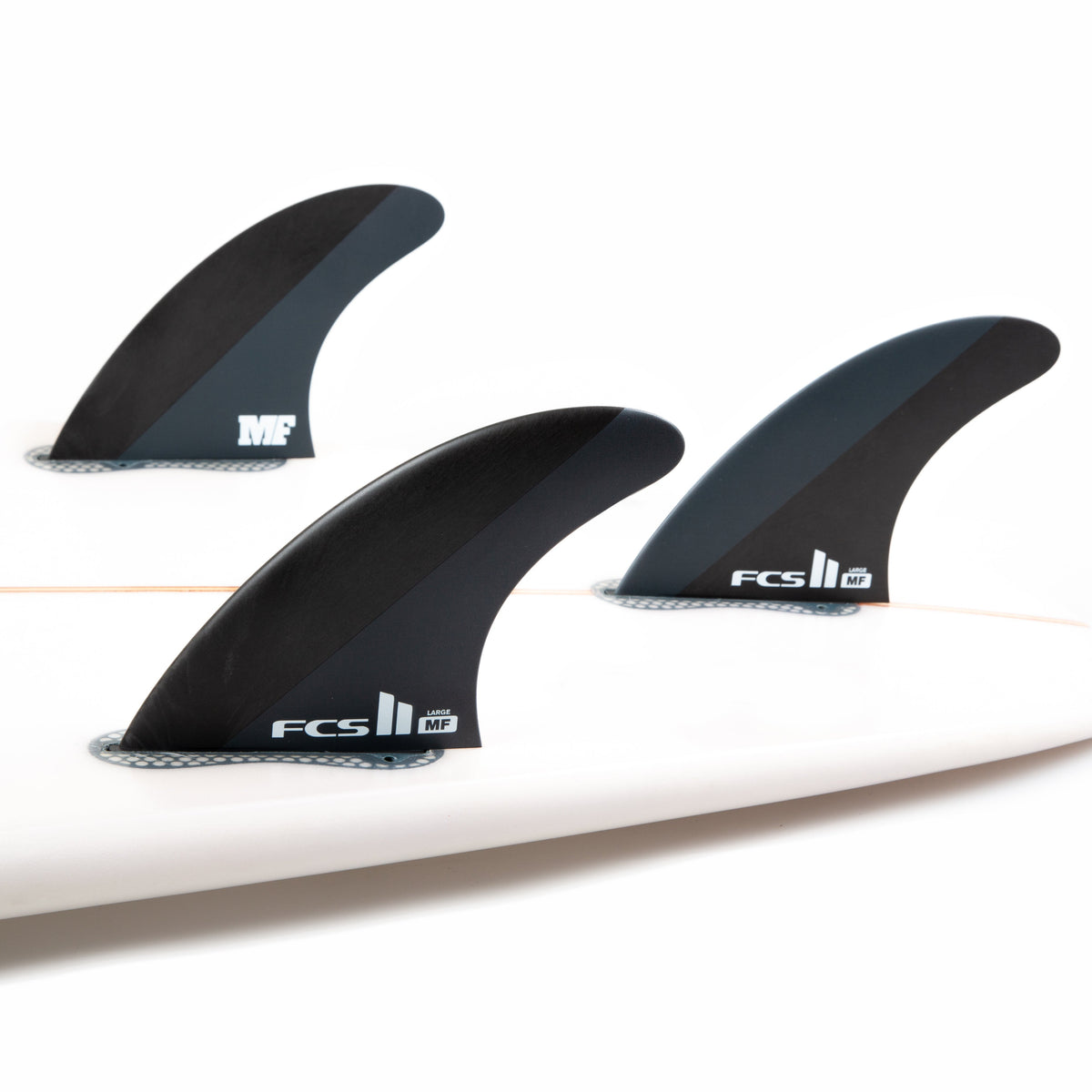 FCS II Mick Fanning Tri Fins - Neo Carbon: three Neo Carbon fins mounted on a white surfboard