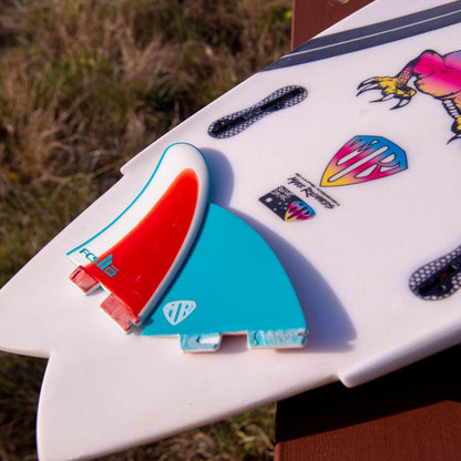 Mark Richards Freeride twin setup on a decorated white surfboard lying on grass