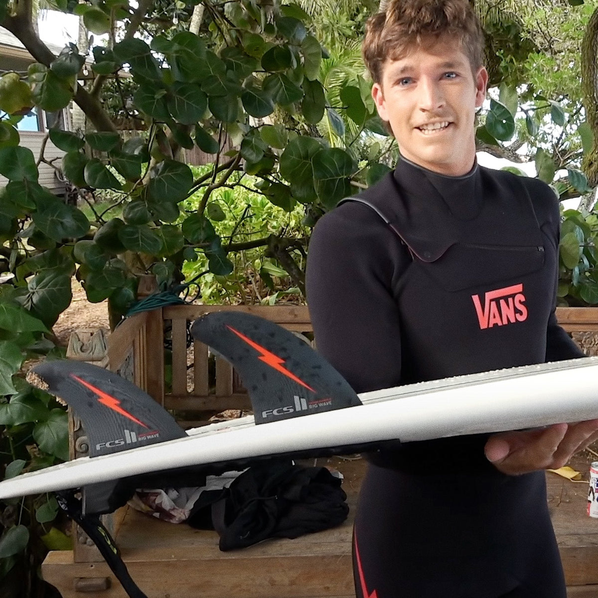 Nathan Florence holding a surfboard fitted with his Big Wave fins outdoors