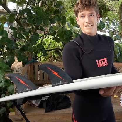 Nathan Florence holding a surfboard fitted with his Big Wave fins outdoors