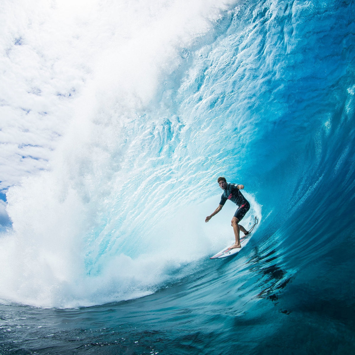Surfer riding inside a large breaking blue wave in the Nathan Florence gallery