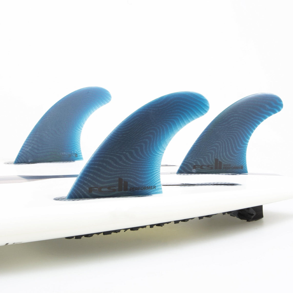 FCS II Performer Tri Fins - Eco Neo Glass: three Pacific fins mounted on the underside of a white board