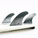 FCS II Tokoro Tri Fins - Performance Core: three Tokoro fins installed on a white board