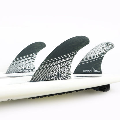 FCS II Tokoro Tri Fins - Performance Core: three Tokoro fins installed on a white board