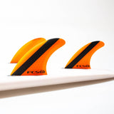 Orange Medium FCS ARC thruster set fitted to a white surfboard
