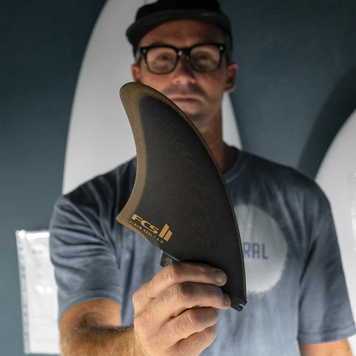 FCS II Album Keel Twin Fin Set - Performance Glass: shaper holding a black and gold Album keel