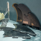 FCS II Album Keel Twin Fin Set - Performance Glass: album fins on a shaping workshop table