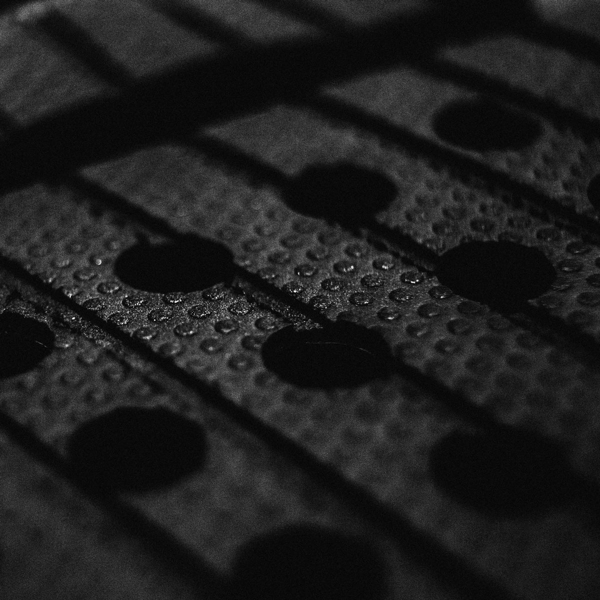 FCS Kolohe Andino Treadlite Traction: close view of micro-dot traction and circular perforations in the black foam