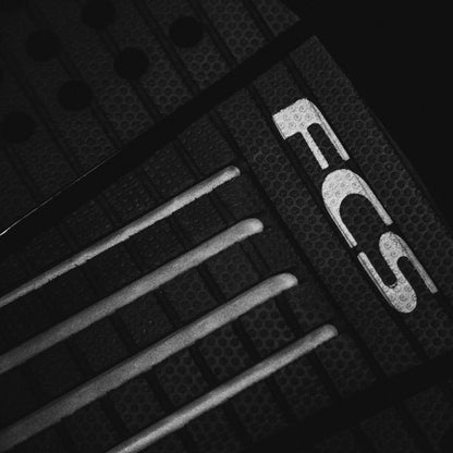 FCS Julian Wilson Treadlite Traction: angled view of the centre arch channels beside the FCS logo
