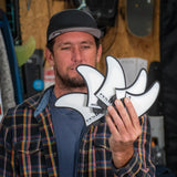 FCS II Harley Mid Tri-Quad Fin Set - Performance Core + AirCore: man holding the Harley fin set in a workshop