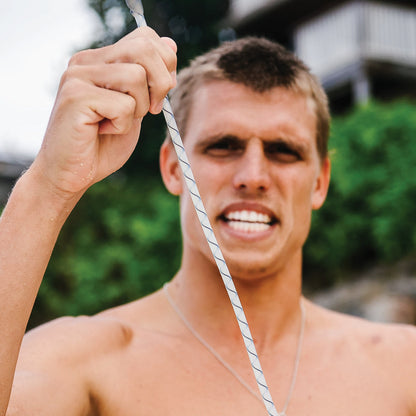 FCS Freedom Helix Leash - All Round: surfer demonstrating cord stretch with both hands