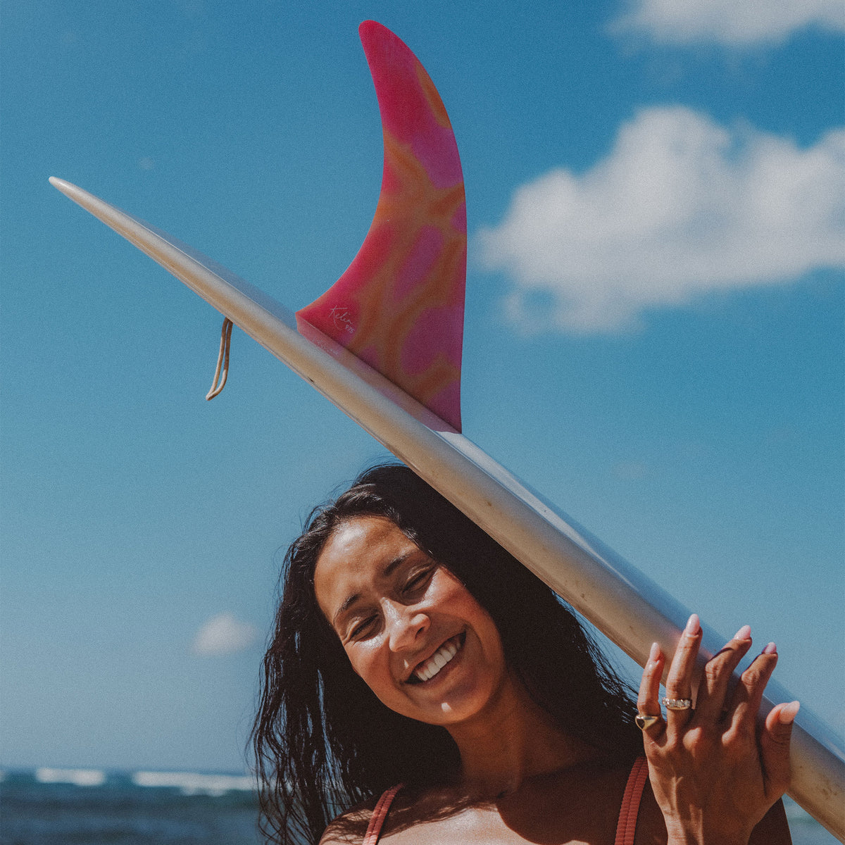FCS II Kelia Moniz Longboard Fin - Performance Glass: kelia carrying a board fitted with the Sunset Glass fin