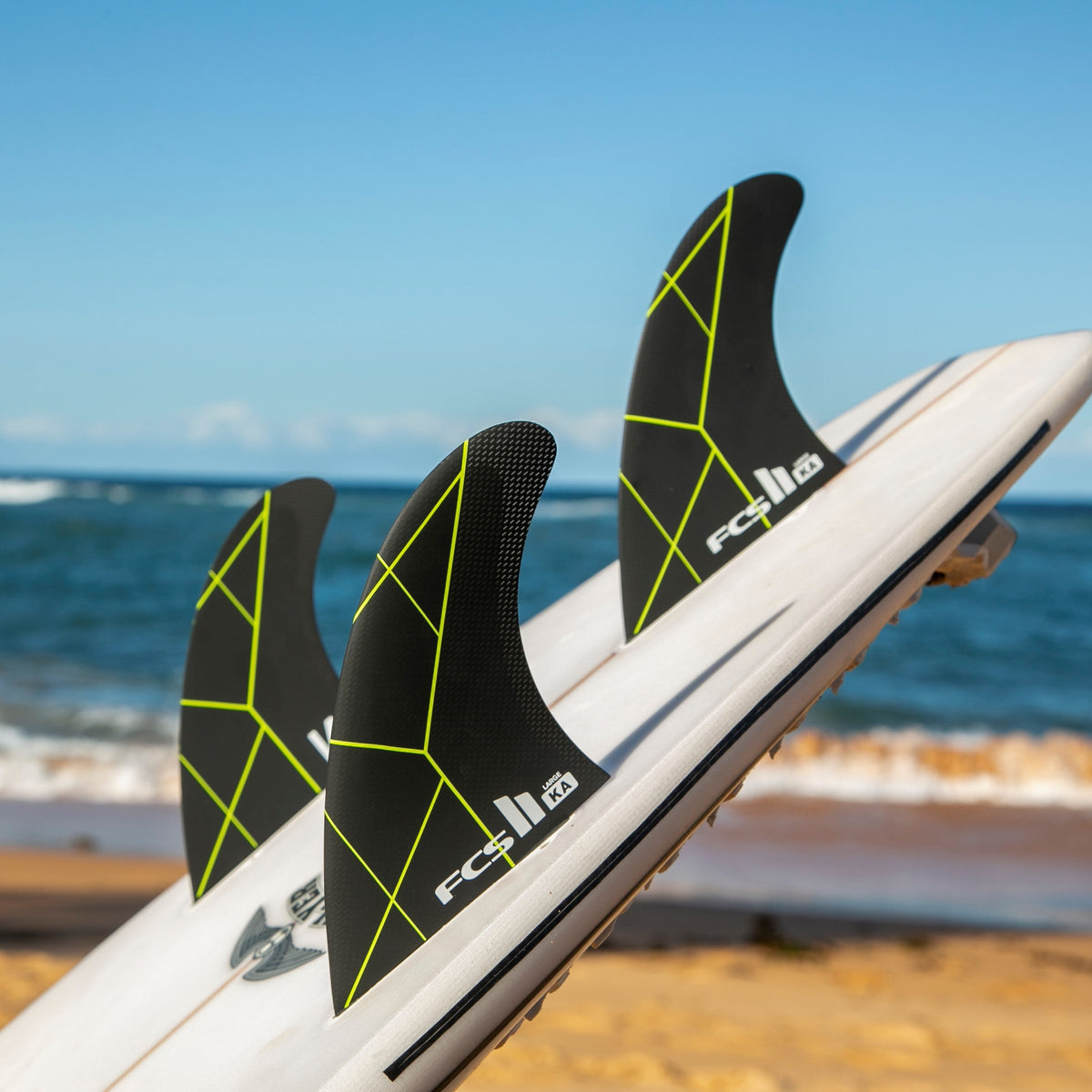 FCS II Kolohe Andino Tri Fins - Performance Core: black and Acid thruster setup photographed by the sea
