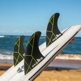 FCS II Kolohe Andino Tri Fins - Performance Core: black and Acid thruster setup photographed by the sea