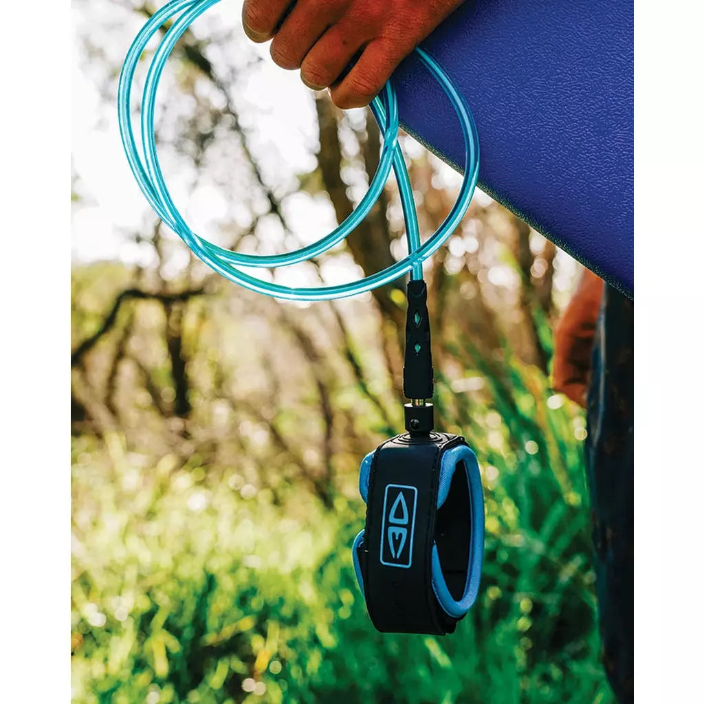 Ocean & Earth Diamond Flex Regular Leash – 6 ft: Blue leash carried with a surfboard
