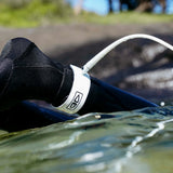 Ocean & Earth Slimline Ultra-Light Pro Comp One-XT Leash – 6 ft: White leash worn over a wetsuit cuff