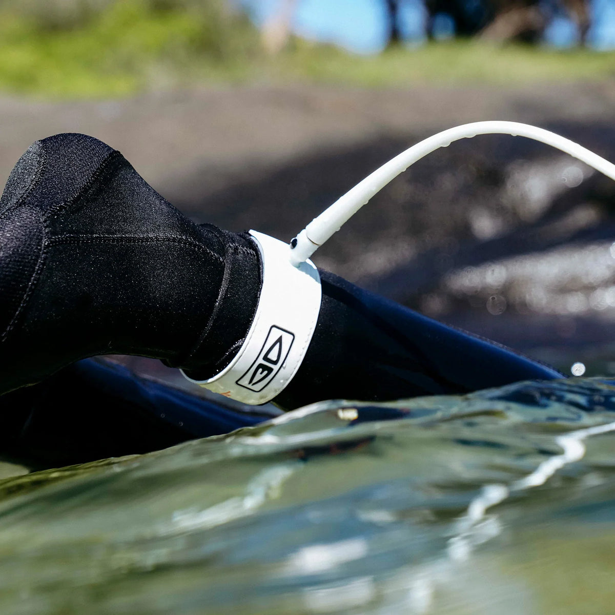 Ocean & Earth Slimline Ultra-Light Pro Comp One-XT Leash – 6 ft: White leash worn over a wetsuit cuff