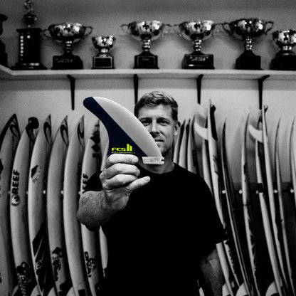 FCS II Mick Fanning PG Pro Tri Fin Set - Performance Glass: black and White portrait of Mick Fanning holding a fin