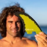 FCS II Mason Ho Tri Fins - PC + AirCore: mason Ho holding his yellow signature fin close to the camera