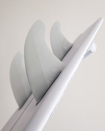 FCS II Mick Fanning Twin + Stabiliser Fins - PC + AirCore: oblique view along a board showing the white twin setup