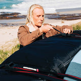 Ocean & Earth Surfboard Rap Rax – Single Stack: Surfer securing a board bag before travel