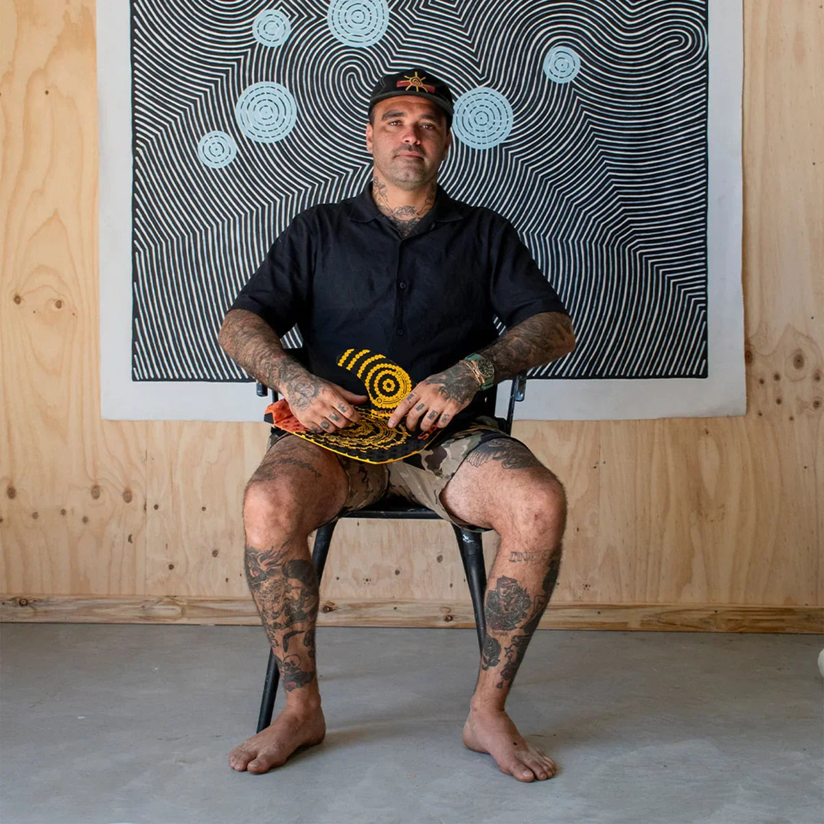 FCS II Otis Carey Twin + Stabiliser Fins - Performance Glass: otis Carey seated beneath his circular artwork
