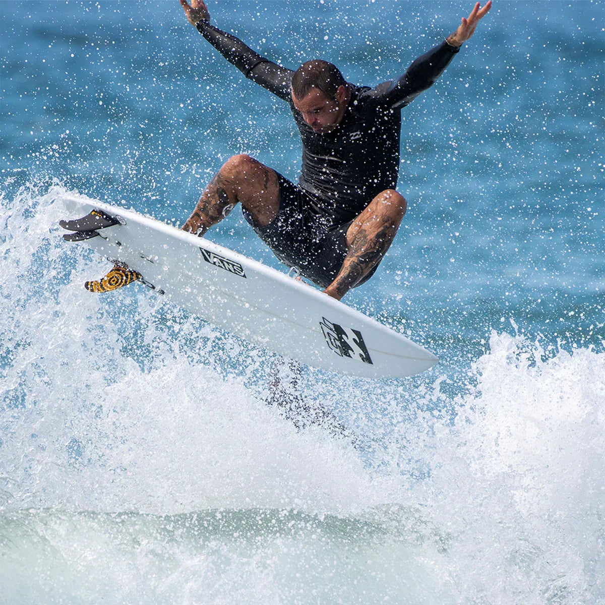 FCS II Otis Carey Twin + Stabiliser Fins - Performance Glass: surfer lifting his board through whitewater
