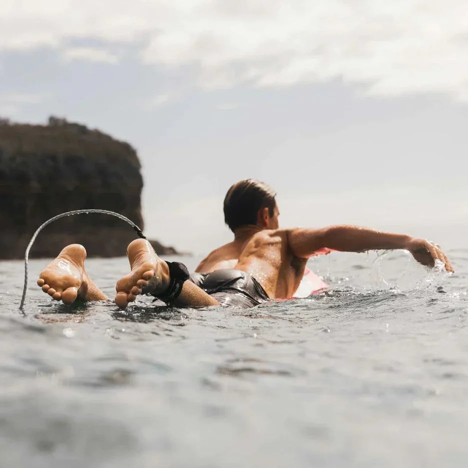 Two surfers sitting with their boards in the ocean