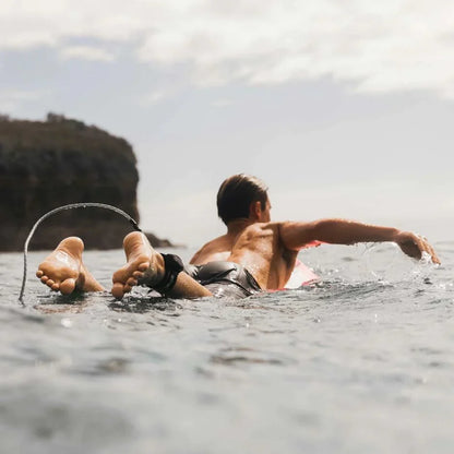 Two surfers sitting with their boards in the ocean