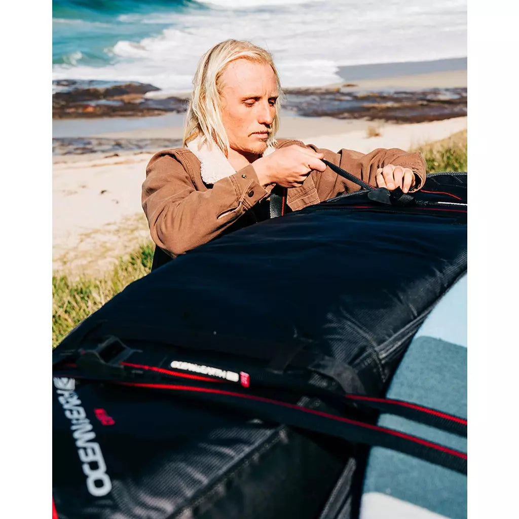 Ocean & Earth Surfboard Tie Down Straps: Surfer securing a board bag on a car