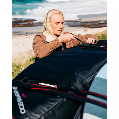 Ocean & Earth Surfboard Tie Down Straps: Surfer securing a board bag on a car