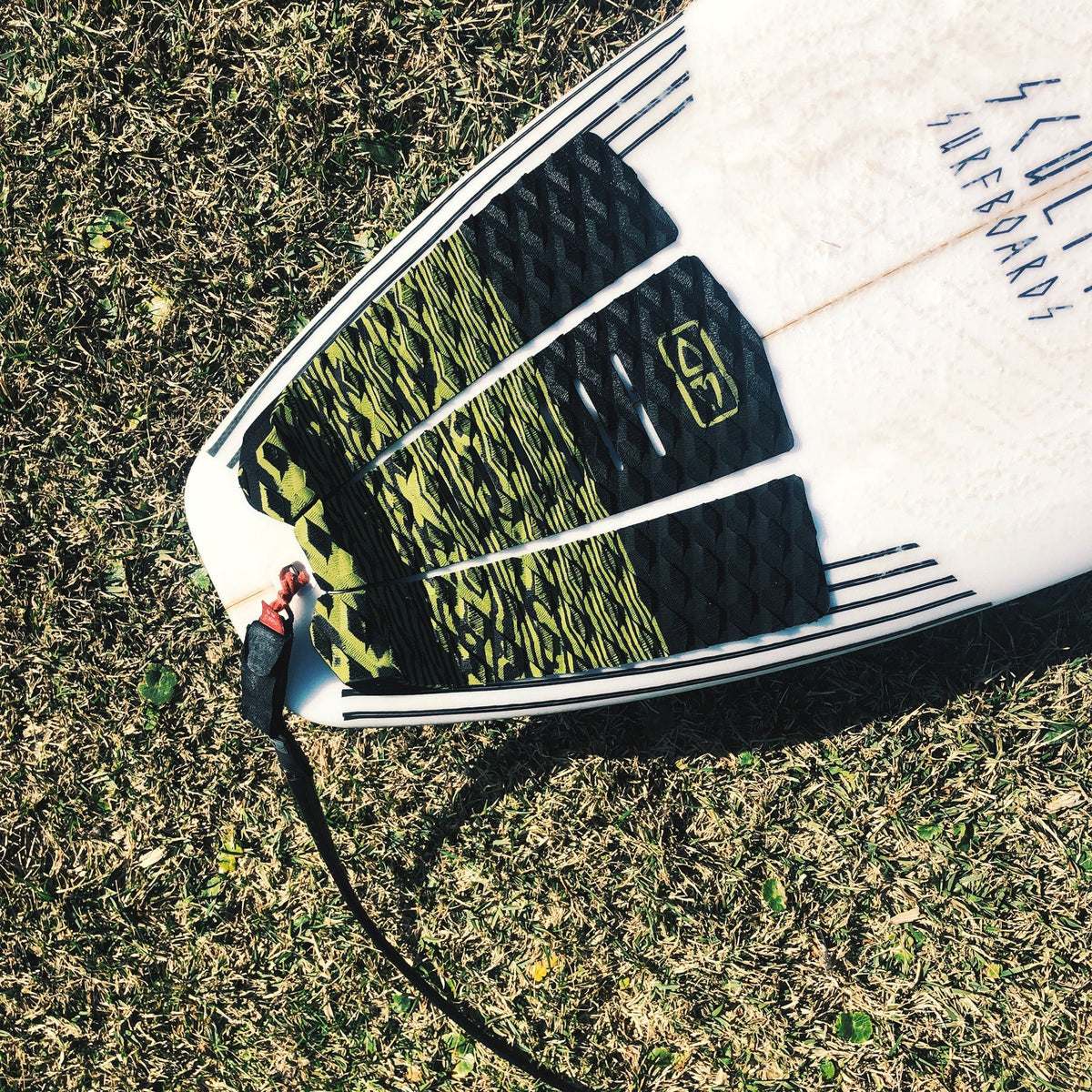 Ocean & Earth Blazed Three-Piece Tail Pad: Olive pad fitted on a surfboard